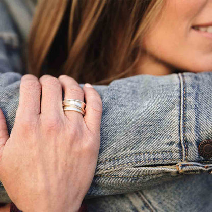 Woman wearing her You Have my Heart Spinner ring with a sterling silver band and gold-filled spinners and phrase engraved on the inside