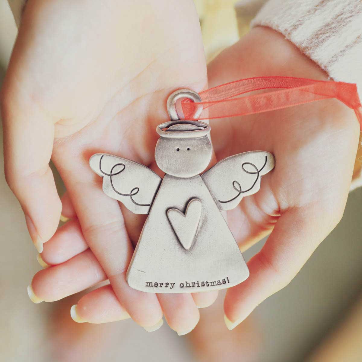 two hands holding the you're my angel ornament