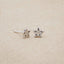 Your Spark Earrings, handcrafted in sterling silver, set with a 1.5mm cubic zirconia, sitting on beige background