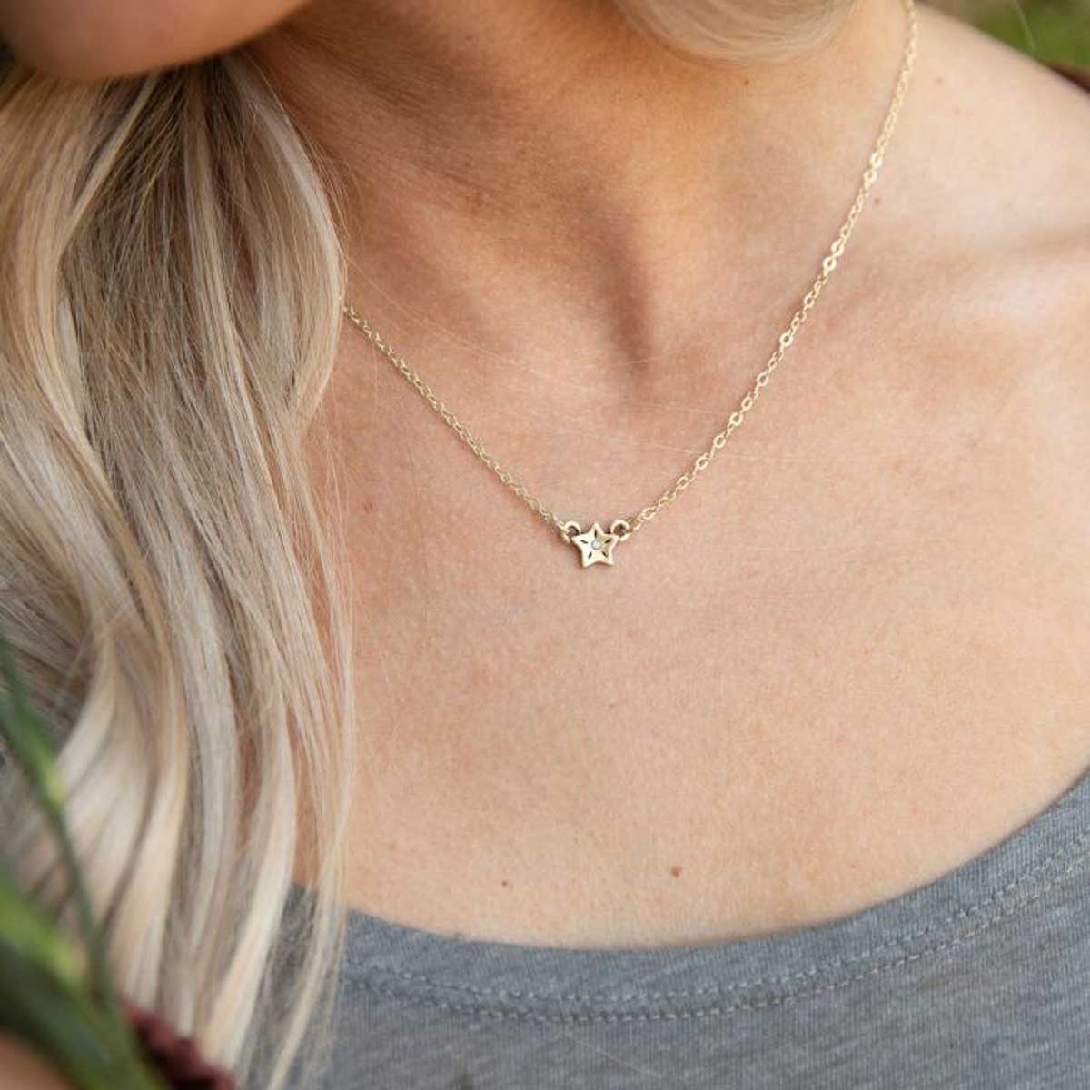 girl wearing 10k yellow gold your spark necklace with 1.5mm cubic zirconia in each star and strung on gold-filled chain